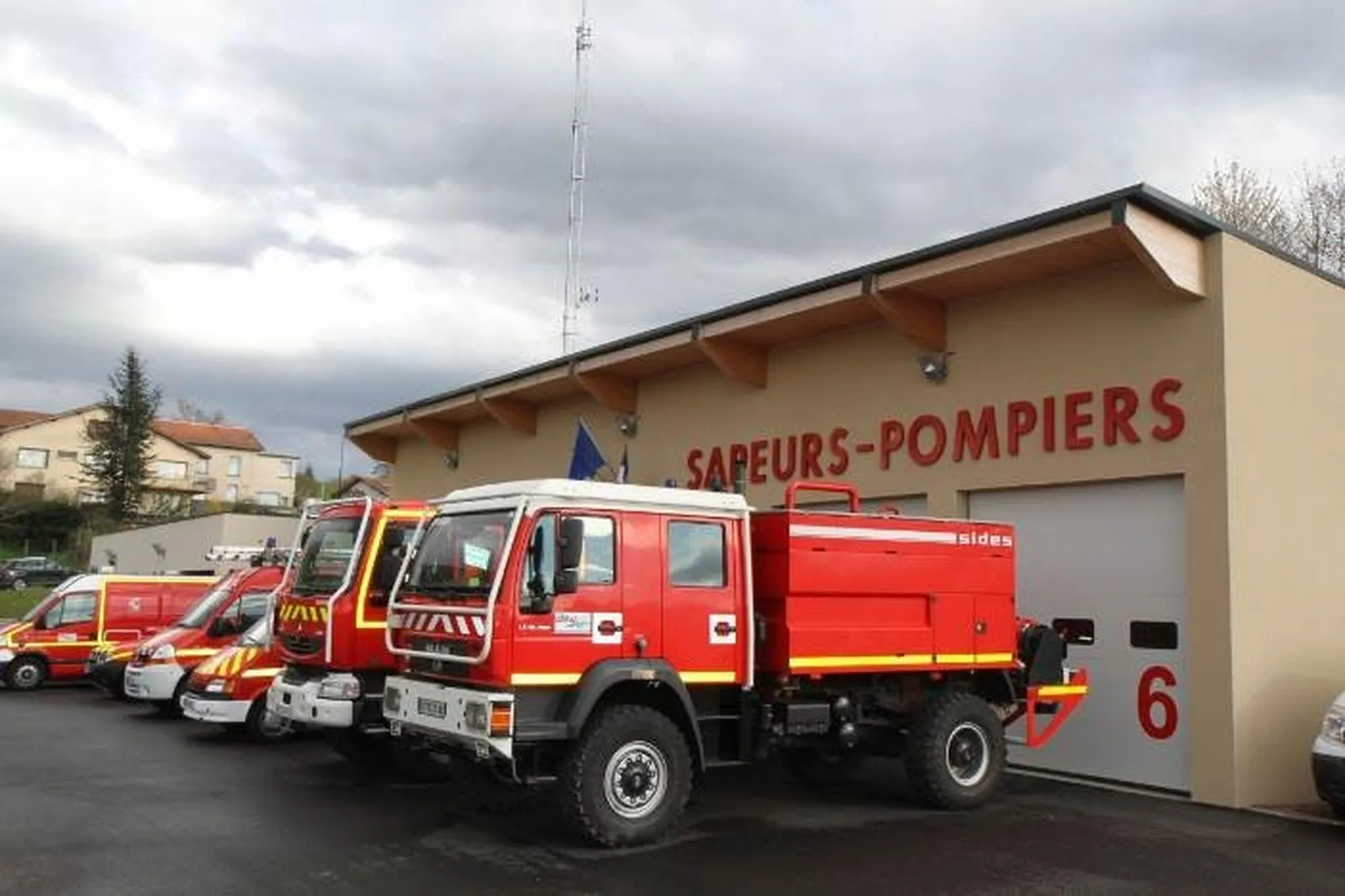 Caserne de sapeurs pompiers avec les véhicules garés devant les garages